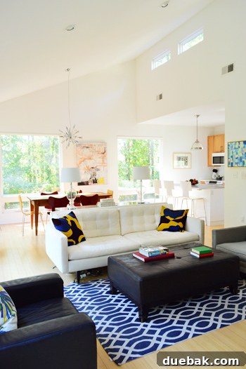 Roommates By Blood 4 Modern dining area with a rustic wooden table, upholstered ottoman, and patterned rug