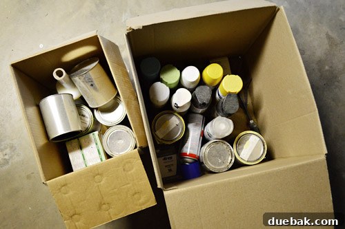 Close-up of cluttered paint cans and boxes