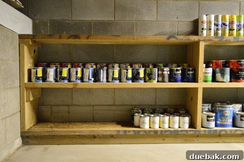 Organized spray paint collection on a tiered shelf