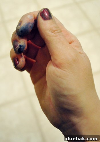 Author's hands with dark nail polish, a styling trick to hide dirt from DIY projects.