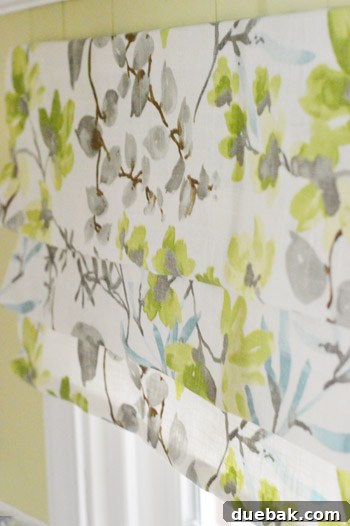 Finished faux roman shade with fabric folds secured by pins, ready for installation