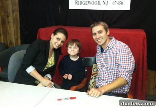 John, Sherry, and Clara interacting with a young fan named Greysen at a book signing