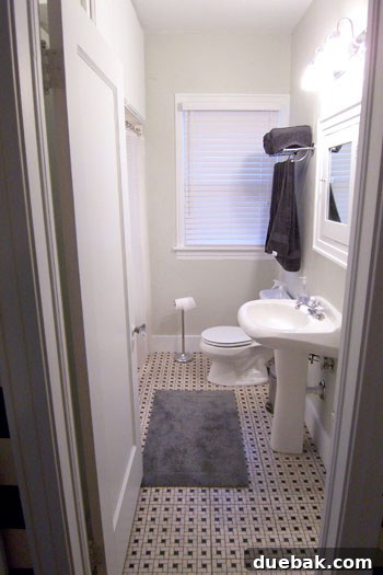 Elegantly renovated bathroom after makeover with basketweave tile, new paint, and updated mirror