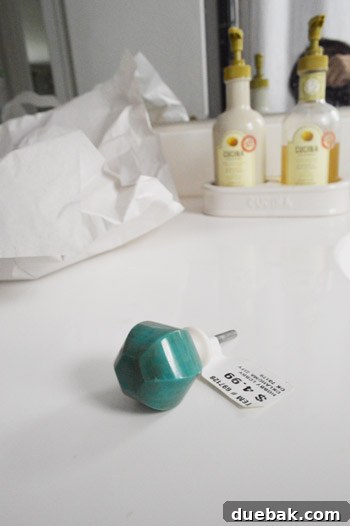 Elevate Your Windows with Frosting 4 Close-up of a new irregular, faceted green-jade-like cabinet knob on a white bathroom vanity