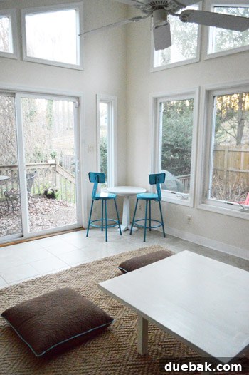 An overhead view of the sunroom, showing the rug, daybed, and stools, illustrating the overall layout and potential for further refinement.