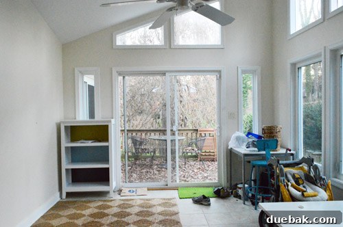 The sunroom's wall overlooking the upper patio, showing an expanse of windows and providing a clear view of the outdoors, awaiting new design.
