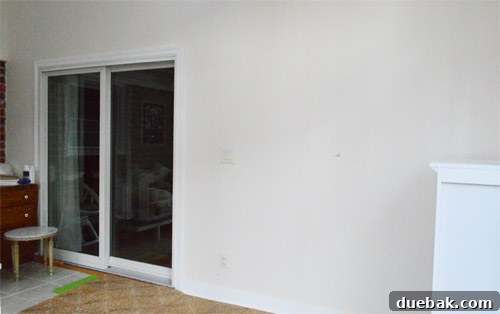 The sunroom's wall adjacent to the living room, showing its integration within the home's layout and its bare state before any design work.