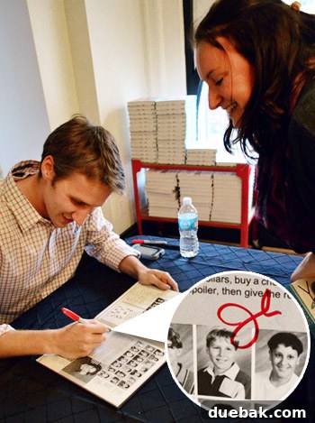 John Petersik signing his middle school yearbook for a former classmate.