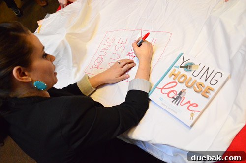 Sherry Petersik sketching her book cover on a sheet for a fan's baby photo project.