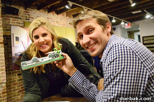 A fan presenting authors with a wooden keepsake of their high school.