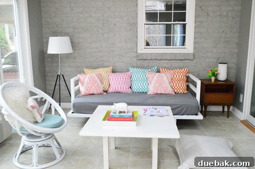 Bright and updated sunroom interior with freshly painted gray brick, highlighting the crisp white trim and natural light.