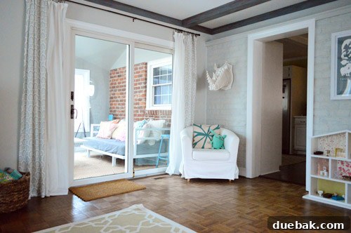 View from the living room couch showing the original unpainted brick in the sunroom, an eyesore for years.
