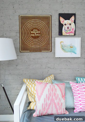 Close-up of a rustic wooden side table next to the brick wall, showcasing some of the art pieces.