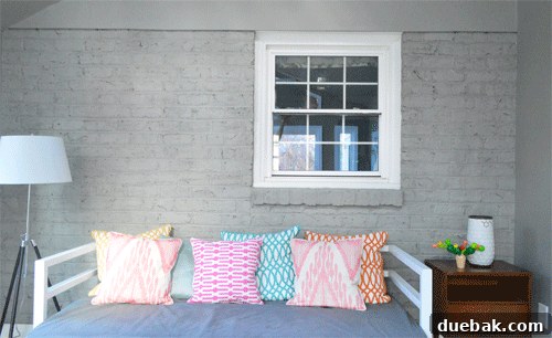 Animated GIF showing the step-by-step process of hanging an eclectic art gallery on a brick wall.