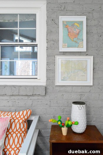 Detailed shot of two framed maps on the right side of the sunroom art wall, showcasing their colors and textures.