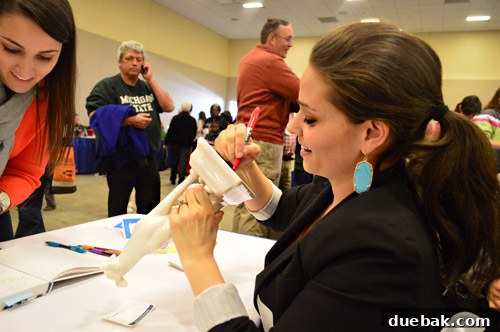 A quirky image of an author signing a ceramic animal.