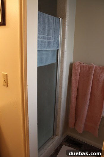 Renovated bathroom with new tiles and modern vanity, reflecting a sleek design