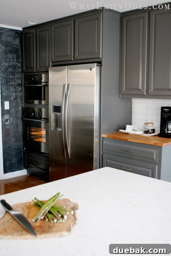 Kitchen interior showing the built-in refrigerator, IKEA appliances, and a fun chalkboard wall