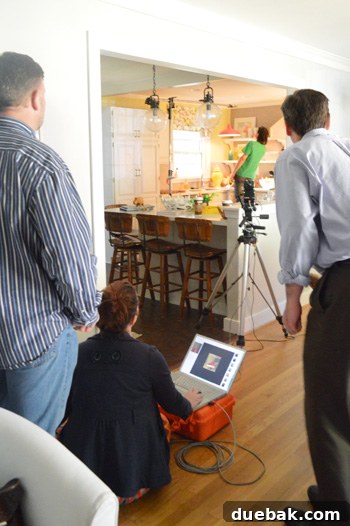 Behind the scenes of the Young House Love photoshoot, showing a crew member holding a light out of frame.