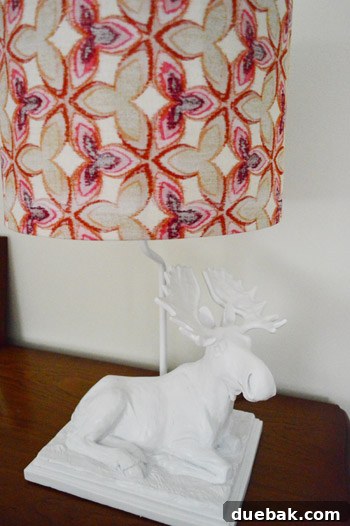 A stylish ceramic moose lamp, painted white, providing soft lighting in Clara's big girl room.