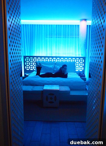 Sherry posing in a stylish hotel room in Miami with blue mood lighting