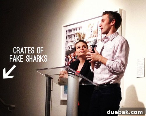 Authors at a book signing podium with a shark exhibit in the background