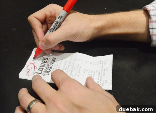 Author signing a Lowe's receipt for a fan