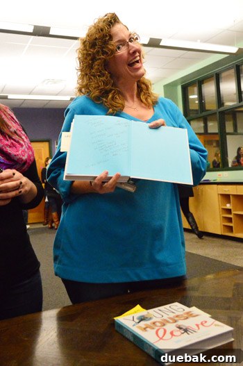 Fan holding a book with insurance information written on the back