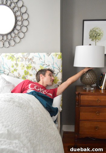 Person performing a stretch to reach the bedside lamp