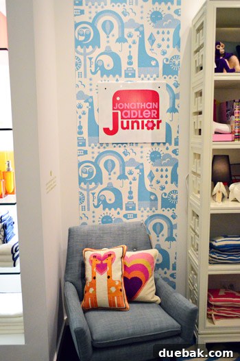 Jonathan Adler kids' section featuring whimsical wallpaper and a charming needlepoint pillow with giraffes.