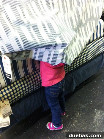 DIY No Sew Ikat Curtains for Playful Kids Spaces 3 Clara, a young girl, excitedly pointing at a navy and white patterned fabric bolt in a store
