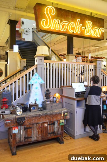 The authors giving a talk at the bottom of a staircase in the Rejuvenation store, with a sign overhead.