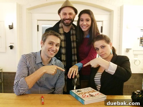 The authors posing with Veronica, who is showing off her engagement ring and a signed book.