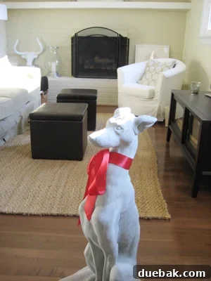 Large concrete greyhound statue with a red bow, a thoughtful home decor gift that adds elegance to any space.