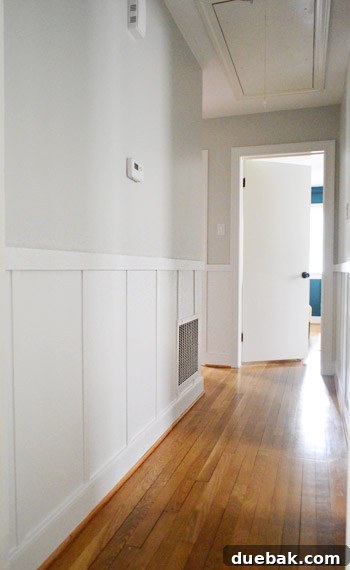 Partially painted board and batten in a hallway, showing progress