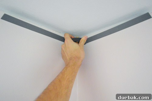 Mastering Crown Molding Installation 9 John measuring corner of ceiling wall with angle finder tool
