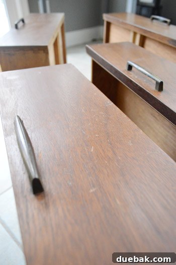 Close-up of media cabinet drawer before restoration showing dryness and scratches