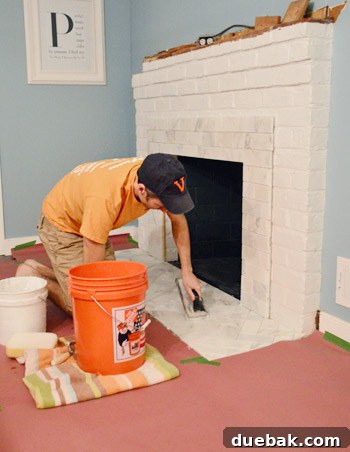 Your Guide to a Stunning Marble Herringbone Fireplace 19 Applying grout to fireplace tiles