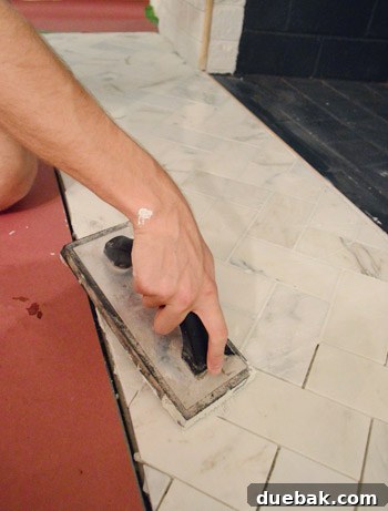 Your Guide to a Stunning Marble Herringbone Fireplace 20 Grouting fireplace tiles in progress