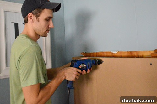 Securing the MDF frame to the brick fireplace using masonry screws and adhesive