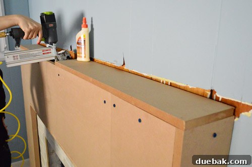 My wife installing the new flat MDF top for the fireplace mantel