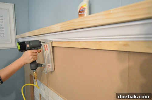 My wife using the nail gun to attach wood strips for crown molding