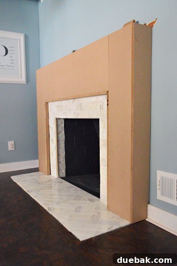 The assembled MDF fireplace frame test-fitted around the existing brick