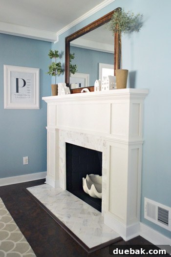 Our $200 Marble Fireplace Glow-Up 12 Another stunning view of the finished DIY fireplace with white mantel and marble tile