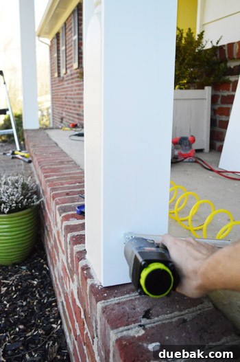 Refreshing Your Porch: Taking Down Scalloped Trim and Repairing Columns 13 Detail shot of a 1x6 inch board being secured to the existing column with wood glue and nails.