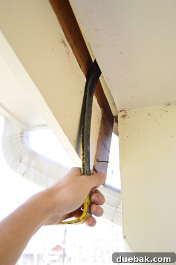 Refreshing Your Porch: Taking Down Scalloped Trim and Repairing Columns 6 Using a crowbar to pry off sections of the curved scalloped trim after it has been loosened.