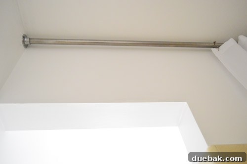 Inside view of the shower with a raised shower rod and extra-long curtain