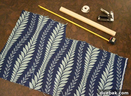 Materials for DIY no-sew window shade: fabric, hem tape, wood, staple gun