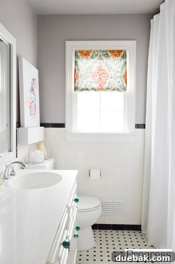 Hall bathroom after renovation, showing framed mirror