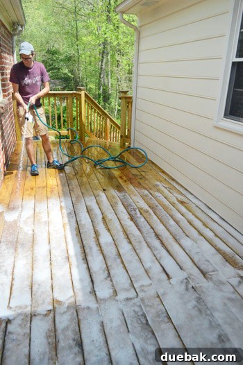 Deck Restoration: A Comprehensive Guide to Staining and Sealing 6 Applying deck cleaner with a garden hose attachment